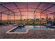 A beautiful screened-in pool and spa area with lounge chairs and a serene view of the sky at sunset at 2907 Fable St, Kissimmee, FL 34746