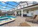 Relaxing screened-in pool area with a spa, backyard view, and patio seating, perfect for outdoor enjoyment at 2907 Fable St, Kissimmee, FL 34746