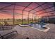 Screened-in pool and spa with lounge chairs, offering a tranquil retreat with picturesque sunset views in the backyard at 2907 Fable St, Kissimmee, FL 34746