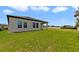 Expansive backyard featuring a well-maintained lawn and a covered patio, perfect for outdoor living at 311 Eaglecrest Dr, Haines City, FL 33844