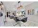 Dining area featuring an island, black chairs, pendant lighting, and sleek white tile flooring at 311 Eaglecrest Dr, Haines City, FL 33844