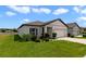 Well-kept home featuring green lawn, tidy landscaping, and a two-car garage under a partly cloudy sky at 311 Eaglecrest Dr, Haines City, FL 33844