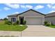 Charming one-story home with well-manicured lawn and a two-car garage on a sunny day at 311 Eaglecrest Dr, Haines City, FL 33844