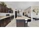 Well-lit kitchen with dark cabinets, stainless appliances, an island with bar seating and lots of counter space at 311 Eaglecrest Dr, Haines City, FL 33844
