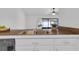 A kitchen sink with modern faucet, white cabinets, and views into the sunroom through the sliding glass doors at 3153 Greenwood St # Winter Spr, Winter Park, FL 32792