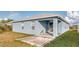 Back of light blue home with a white roof and windows, with a covered area and patio at 316 Bennett St, Auburndale, FL 33823