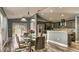 Open dining room with a modern glass table, leading into the kitchen with stainless steel appliances at 316 Bennett St, Auburndale, FL 33823