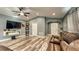 Bright living room featuring modern flooring, a ceiling fan, and a wall-mounted entertainment center at 316 Bennett St, Auburndale, FL 33823