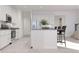 Spacious kitchen featuring white cabinetry, stainless steel appliances, and a stylish island with barstools at 326 Puma Loop, Groveland, FL 34736