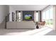 Bright, open living area with a modern sofa, TV, and large windows with scenic views and natural light at 326 Puma Loop, Groveland, FL 34736