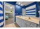 Bright blue bathroom with double vanity and view to bedroom with bunk beds at 3267 Regal Crest Dr, Longwood, FL 32779