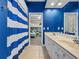 Blue-themed bathroom with double vanity and striped shower curtain at 3267 Regal Crest Dr, Longwood, FL 32779