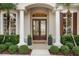 Stunning home exterior featuring double front doors, stately columns, and lush landscaping at 3267 Regal Crest Dr, Longwood, FL 32779