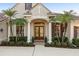 Elegant home entrance highlighting the arched doorway, decorative columns, and detailed landscaping at 3267 Regal Crest Dr, Longwood, FL 32779