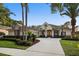 Charming home exterior with swaying palm trees, lush landscaping, and a circular driveway enhancing curb appeal at 3267 Regal Crest Dr, Longwood, FL 32779
