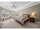 Comfortable main bedroom featuring a large bed, tray ceiling, and bright windows at 3267 Regal Crest Dr, Longwood, FL 32779
