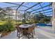 Outdoor dining with stone table and chairs beside the pool within a screened patio at 3267 Regal Crest Dr, Longwood, FL 32779