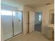 This bathroom features a glass enclosed shower and a vanity at 335 Ridgemark Ave, Groveland, FL 34736