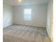 Spacious bedroom with neutral carpet and a large window at 335 Ridgemark Ave, Groveland, FL 34736