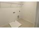 Bright laundry room features wire shelving, utility connections, and neutral flooring at 335 Ridgemark Ave, Groveland, FL 34736