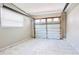 Attached garage with white marble-look tiled floor, window, and white paneled door at 3362 Janet St, Apopka, FL 32712