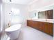 Bathroom featuring double sinks, a soaking tub, and large window for natural light at 3417 Bay Meadow Ct, Windermere, FL 34786