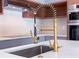 Close-up of a modern kitchen sink with a gold faucet and white countertops at 3417 Bay Meadow Ct, Windermere, FL 34786