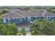 Aerial view of blue townhomes with well-manicured landscaping and mature trees at 3559 Victoria Pines Dr # 280, Orlando, FL 32829