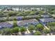 Aerial view of the community showcasing the townhomes, mature trees, and a nearby lake at 3559 Victoria Pines Dr # 280, Orlando, FL 32829