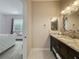 Bathroom with marble countertop, decorative mirror, and doorway to the bedroom at 3559 Victoria Pines Dr # 280, Orlando, FL 32829