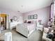 Well-lit bedroom featuring lilac walls, a stylish bed, and carpet flooring at 3559 Victoria Pines Dr # 280, Orlando, FL 32829