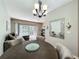 Well-lit dining room with modern chandelier, decorative mirror, and sliding door views to outdoor patio at 3559 Victoria Pines Dr # 280, Orlando, FL 32829