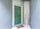 Inviting green front door with a welcome mat and sign, creating a warm entrance at 3559 Victoria Pines Dr # 280, Orlando, FL 32829