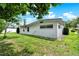 The exterior of the house extends into a backyard featuring well-maintained grass and shading trees at 3716 Neptune Dr, Orlando, FL 32804