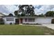 Charming single-story home featuring a well-maintained lawn, an attached garage, and a welcoming red front door at 3716 Neptune Dr, Orlando, FL 32804