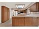 Well-lit kitchen featuring wood cabinets, a skylight, and durable laminate flooring at 3716 Neptune Dr, Orlando, FL 32804