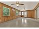 Large room with wood paneling, windows, and a ceiling fan, providing ample space at 3716 Neptune Dr, Orlando, FL 32804