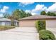 Beige one-story home featuring an attached two-car garage, and partial landscaping at 378 Cedarbrook Ln, Altamonte Springs, FL 32714