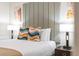 Bedroom featuring a plush queen bed with patterned pillows and a stylish headboard at 4001 Breakview Dr # D409, Orlando, FL 32819