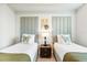Nicely decorated bedroom featuring two twin beds and a nightstand with lamp at 4001 Breakview Dr # D409, Orlando, FL 32819