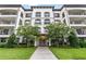 Beautiful condo building featuring a well-maintained lawn and flowering trees at 4001 Breakview Dr # D409, Orlando, FL 32819
