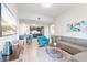 Bright living room with modern decor, gray sofa, blue chair, and kitchen area at 4001 Breakview Dr # D409, Orlando, FL 32819