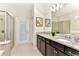 Bathroom featuring double sinks with granite countertops and a glass-enclosed shower at 4021 Lana Ave, Davenport, FL 33897