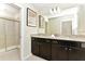 Well-appointed bathroom features double sinks, dark wood cabinetry, granite countertops, and a separate shower at 4021 Lana Ave, Davenport, FL 33897