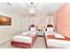 Bedroom with two twin beds, chandelier and pink accents at 4021 Lana Ave, Davenport, FL 33897