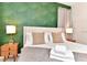 Inviting bedroom featuring a leaf-patterned accent wall, soft lighting, and neutral decor at 4021 Lana Ave, Davenport, FL 33897