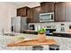 Modern kitchen with stainless steel appliances, dark cabinets, granite countertops, and modern backsplash at 4021 Lana Ave, Davenport, FL 33897