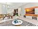 Bright open-concept living room with modern furnishings, dining area, and a TV with a light wood display at 4021 Lana Ave, Davenport, FL 33897