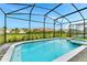 Beautiful screened-in pool with a spa and views of the backyard and neighboring homes at 4021 Lana Ave, Davenport, FL 33897