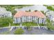 Aerial view of a condo building with a tile roof, landscaping, and a parking lot near a lake at 4114 Breakview Dr # 110, Orlando, FL 32819
